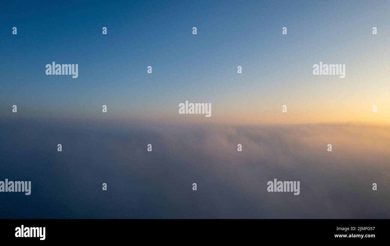 Vista aerea. Volare nella nebbia, volare nella nebbia sopra le nuvole del mattino presto nel sole che sorge. Ripresa da fotocamera aerea. Volo sopra il cl Foto Stock