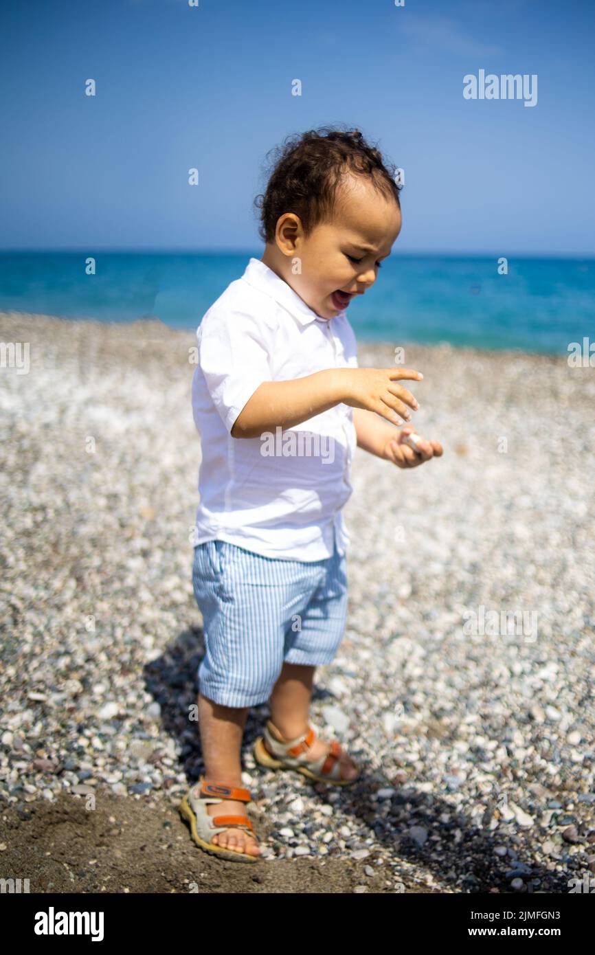 Bambino felice in camicia bianca e pantaloncini blu. Foto Stock