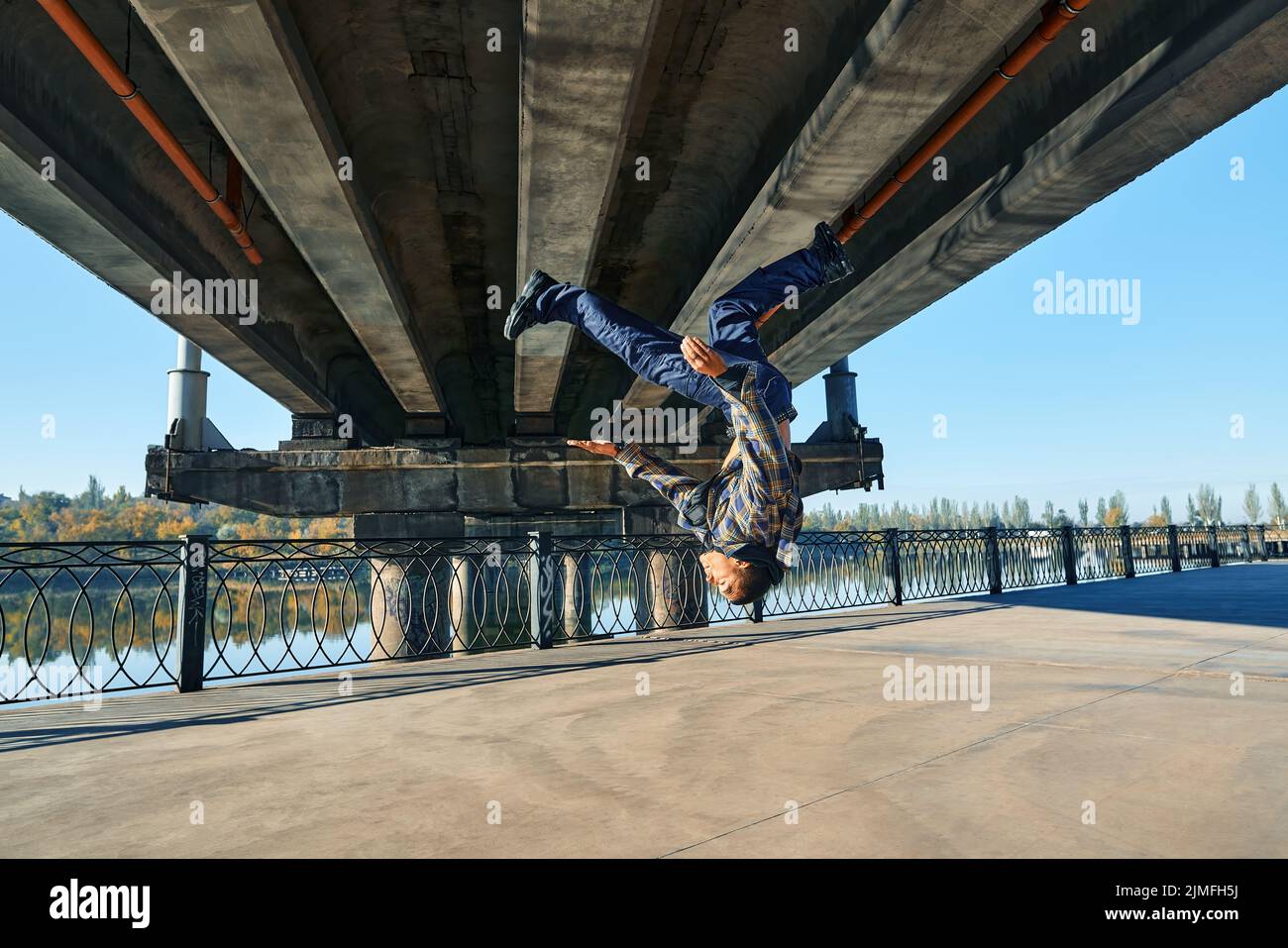 Giovane uomo rompere ballerino facendo somersault acrobazie ballare su sfondo urbano Foto Stock