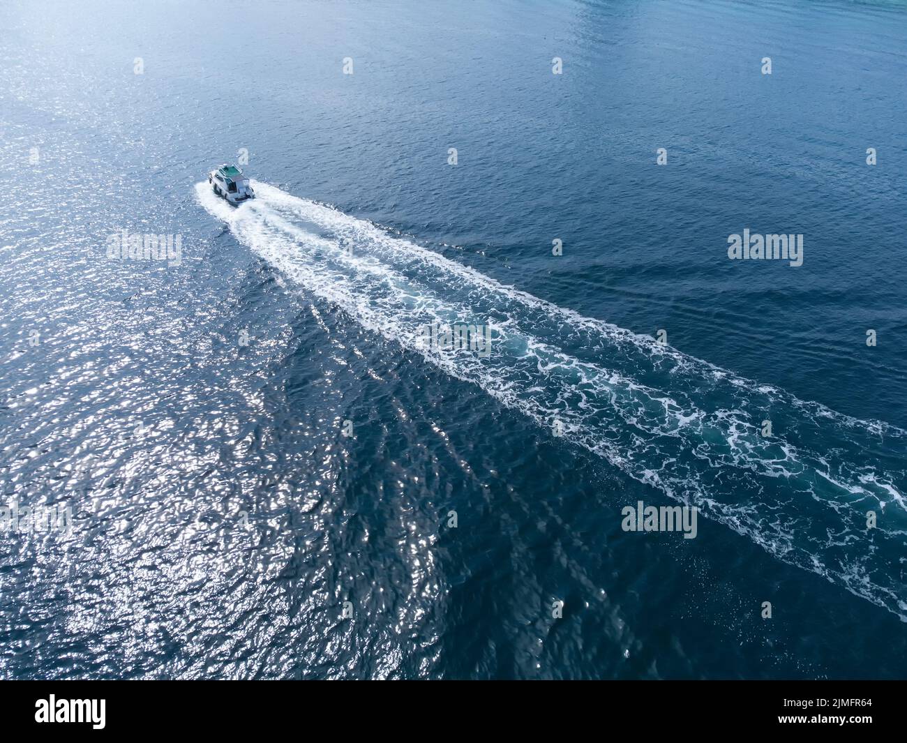Il motoscafo naviga sul mare blu per incontrare il sole. Riposo per i turisti e nuoto in mare. Foto Stock
