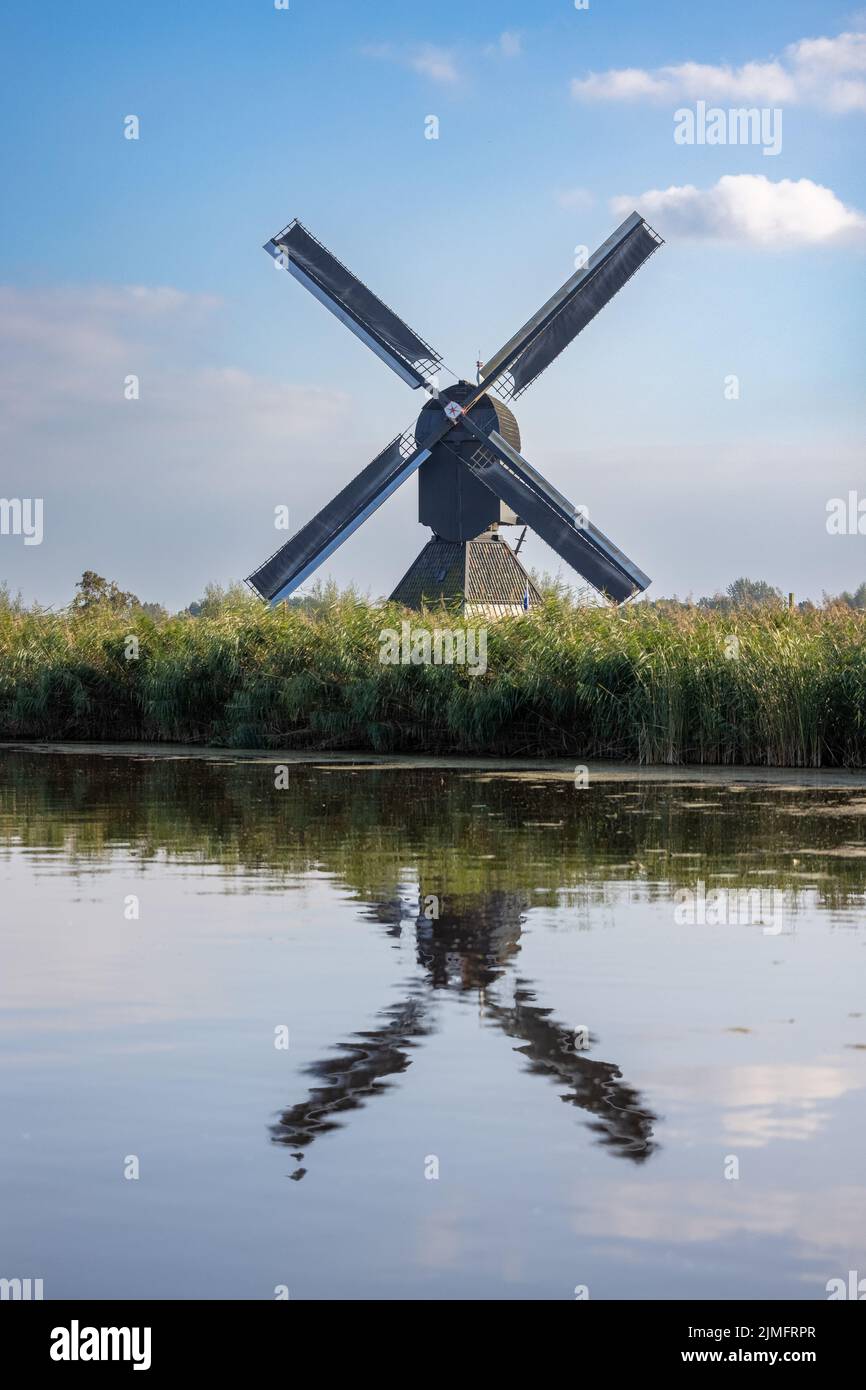 Immagine verticale di uno dei famosi mulini a vento olandesi di Kinderdijk, un sito patrimonio dell'umanità dell'UNESCO. Sulla foto è presente il nero Foto Stock