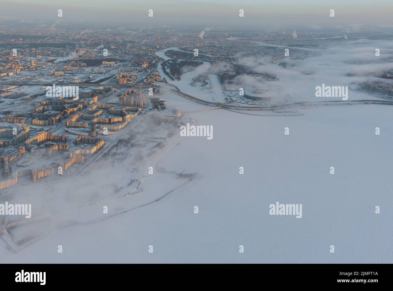 Russia, San Pietroburgo, 08 gennaio 2022: Stadio coperto di neve Gazprom Arena vicino alla superstrada in una serata gelida inverno, vista Foto Stock