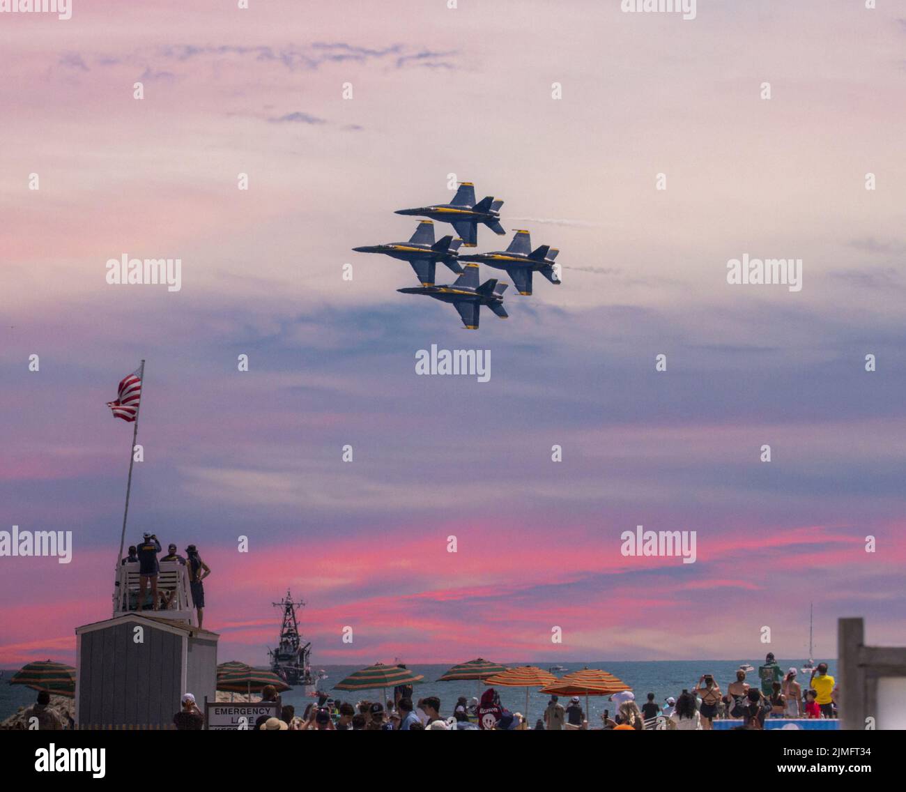 Wantagh, New York, USA - 29 maggio 2022: Quattro getti blu della Marina degli Stati Uniti che volano in formazione su un bagnino stand durante il tramonto alla spiaggia durante un ai Foto Stock