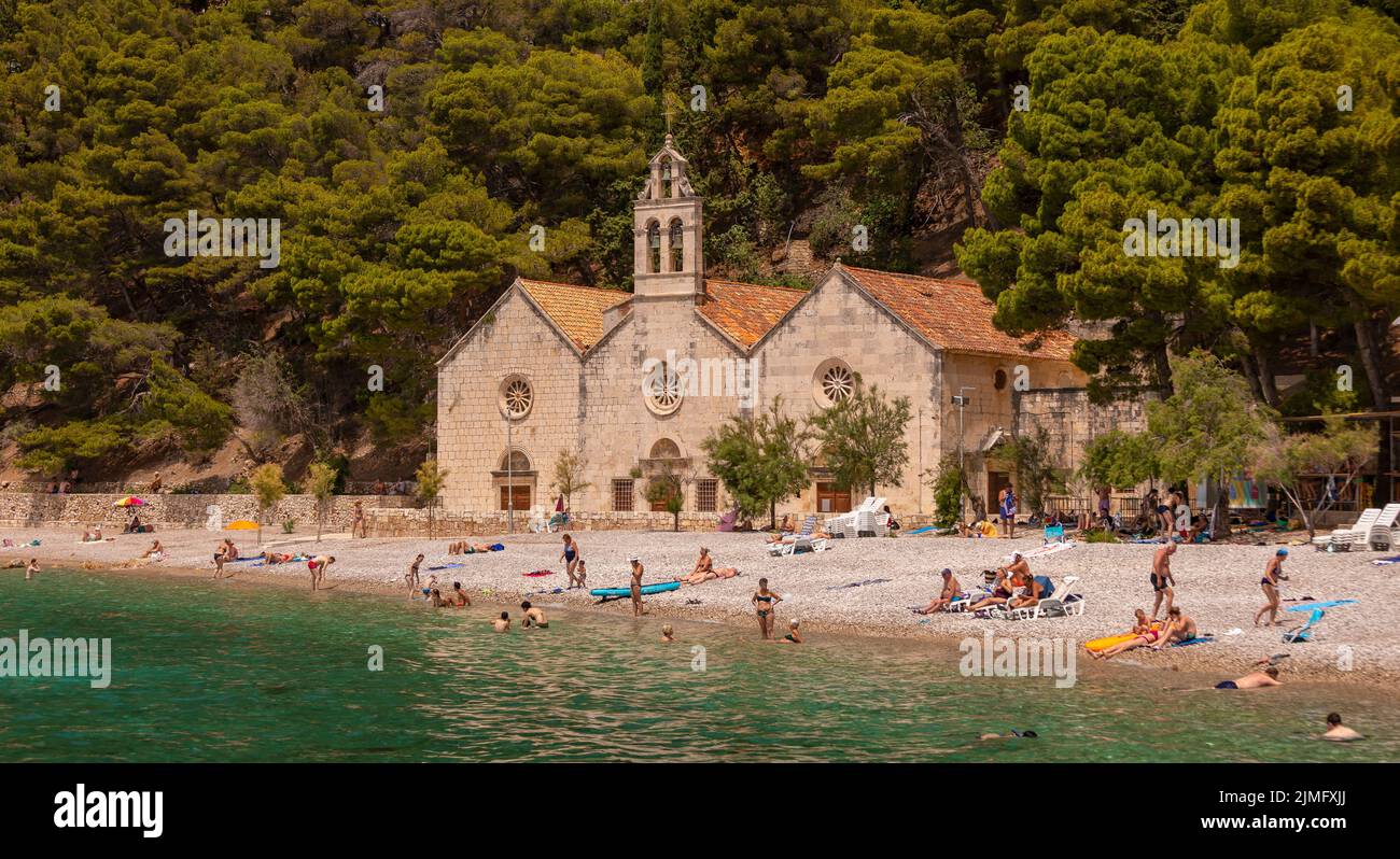 KOMIZA, VIS, CROAZIA, EUROPA - la gente gode la spiaggia nella città costiera di Komiza, sull'isola di Vis, nel mare Adriatico. Foto Stock