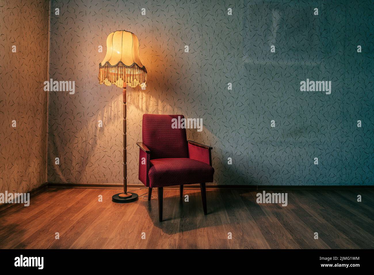 Lampada da terra rustica e poltrone rosse in casa abbandonata. Foto Stock