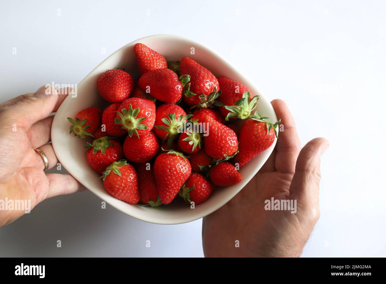 Fragole fresche in cestino su tavola di legno. Direttamente sopra. Foto Stock