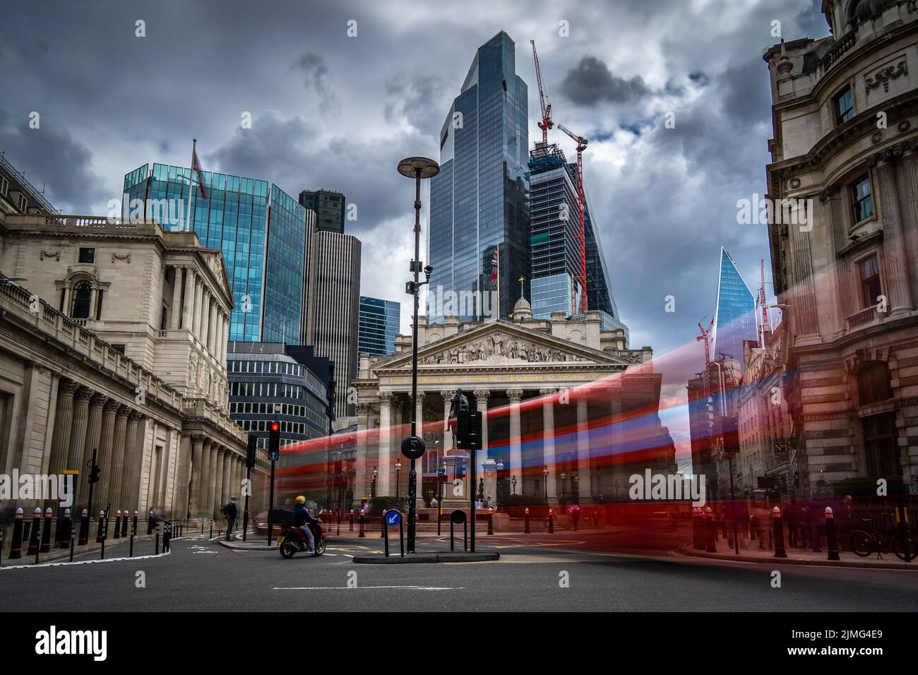 Londra, UK - Giu 09 2022: Vista della strada della Banca d'Inghilterra e della Royal Exchange con un autobus rosso sfocato di fronte Foto Stock