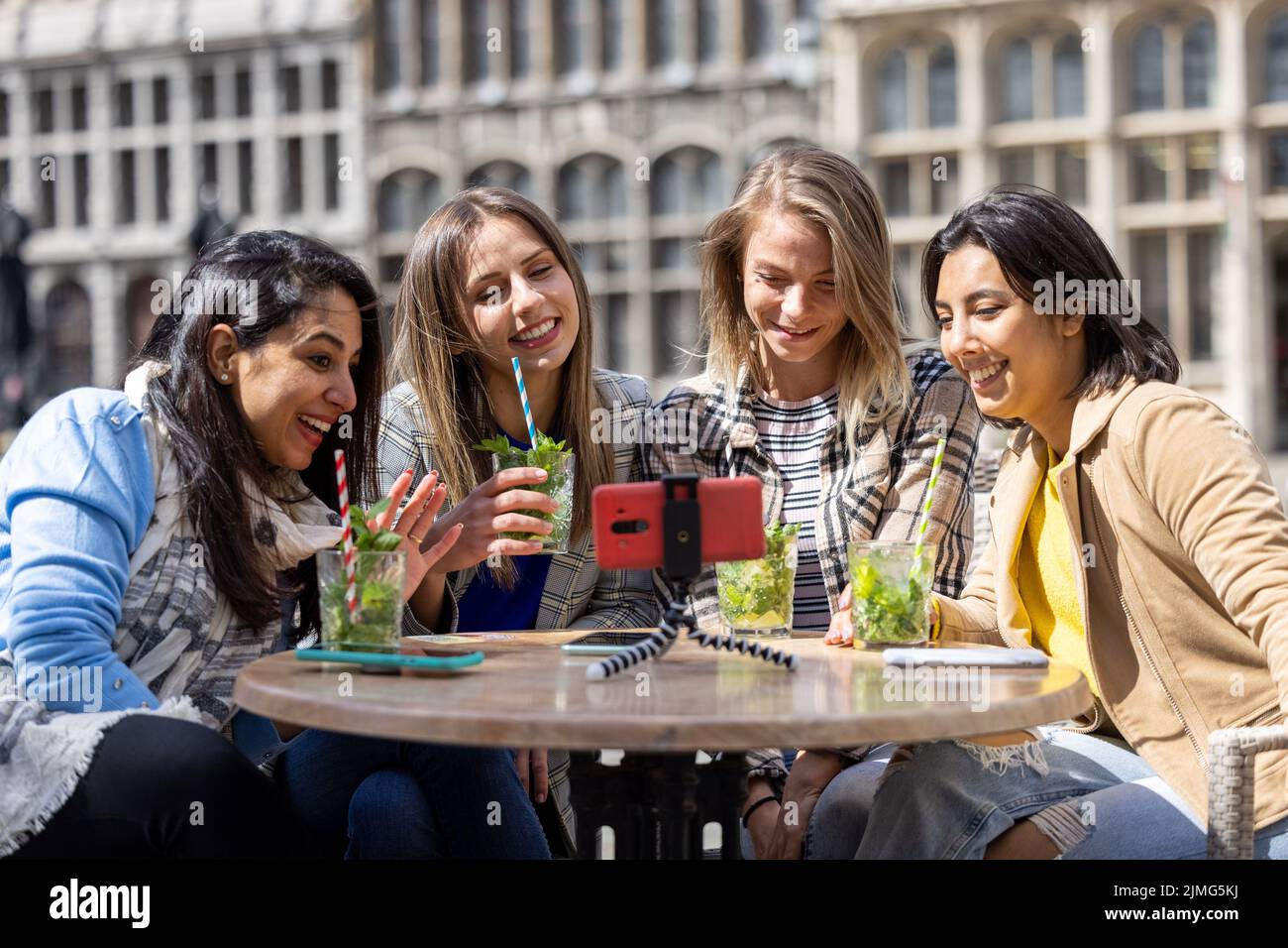 Anversa, Belgio, 21 maggio 2021, quattro amici multietnici, turisti o studenti seduti in una caffetteria sulla terrazza della città Foto Stock