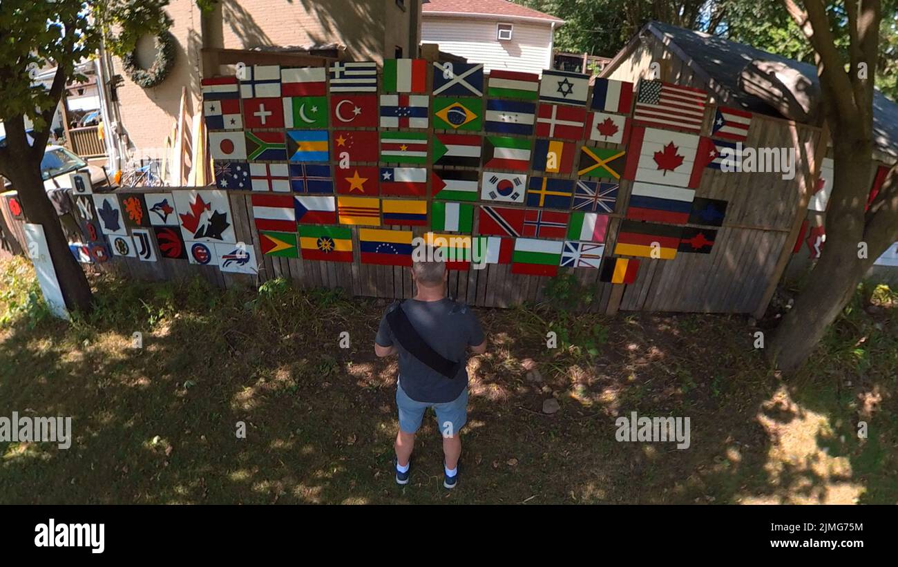 Varie bandiere internazionali e simboli su un muro di Guelph Ontario Foto Stock