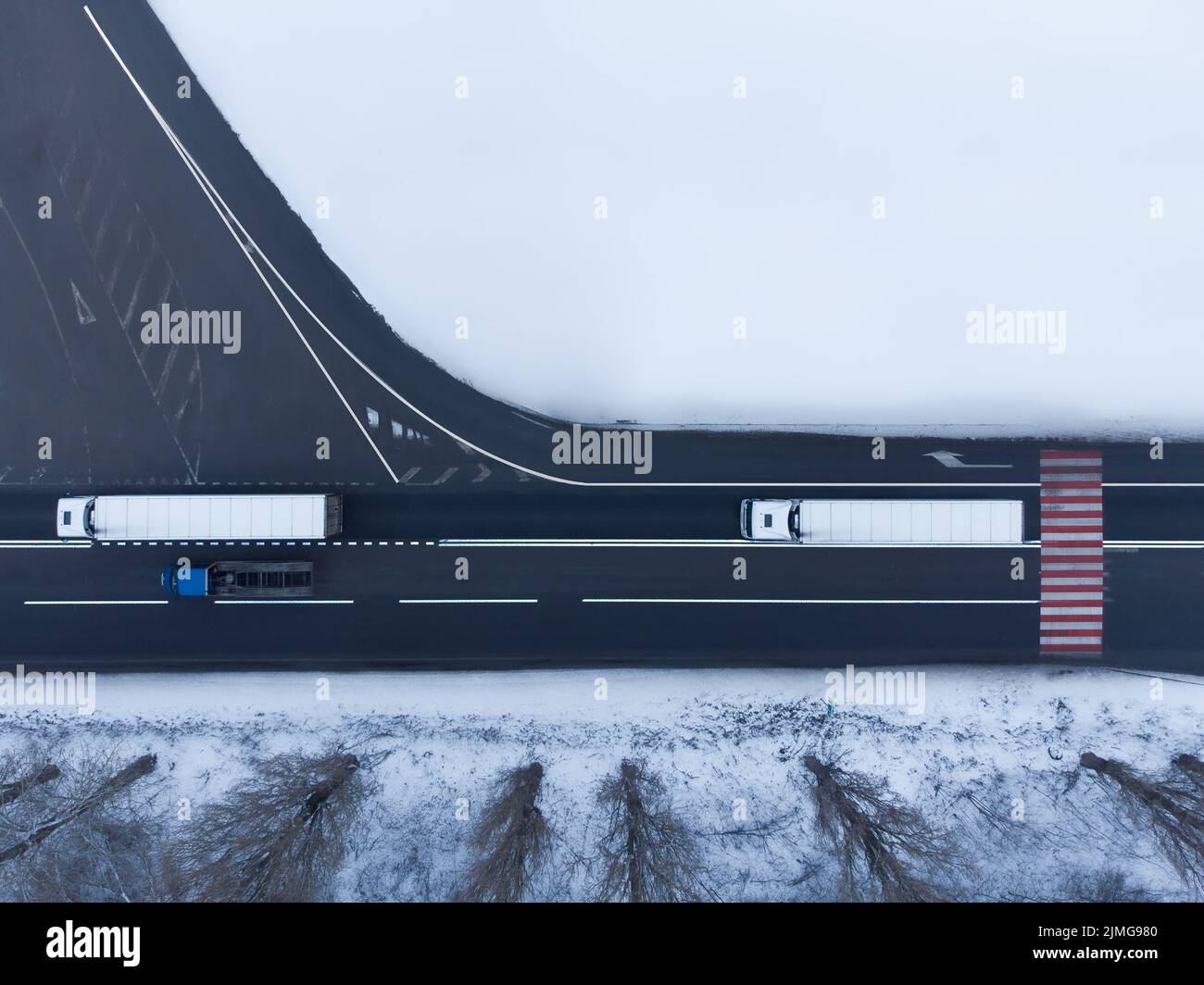 Due camion sulla strada vista dall'aria in inverno. Foto Stock