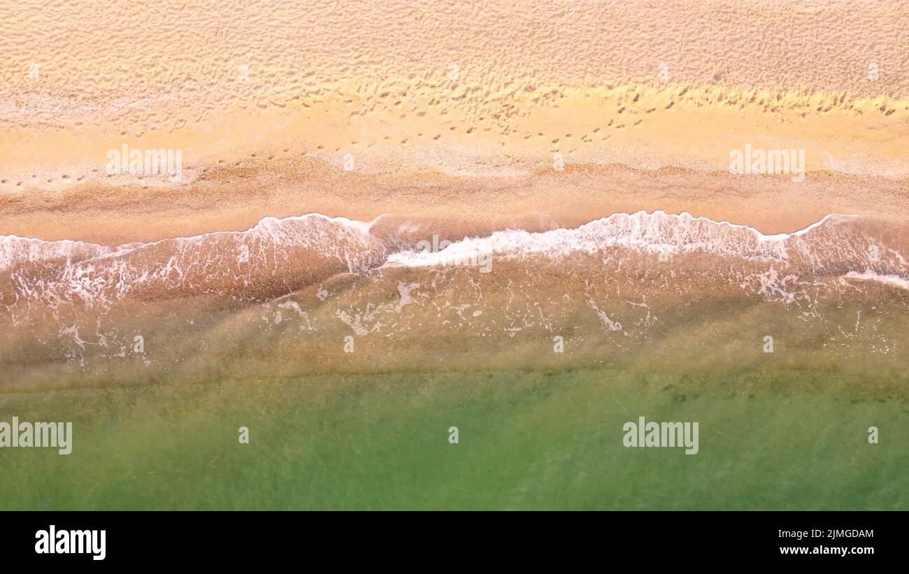 Vista aerea della spiaggia di sabbia. Vista dall'alto sulle onde del mare. Riprese con droni Foto Stock
