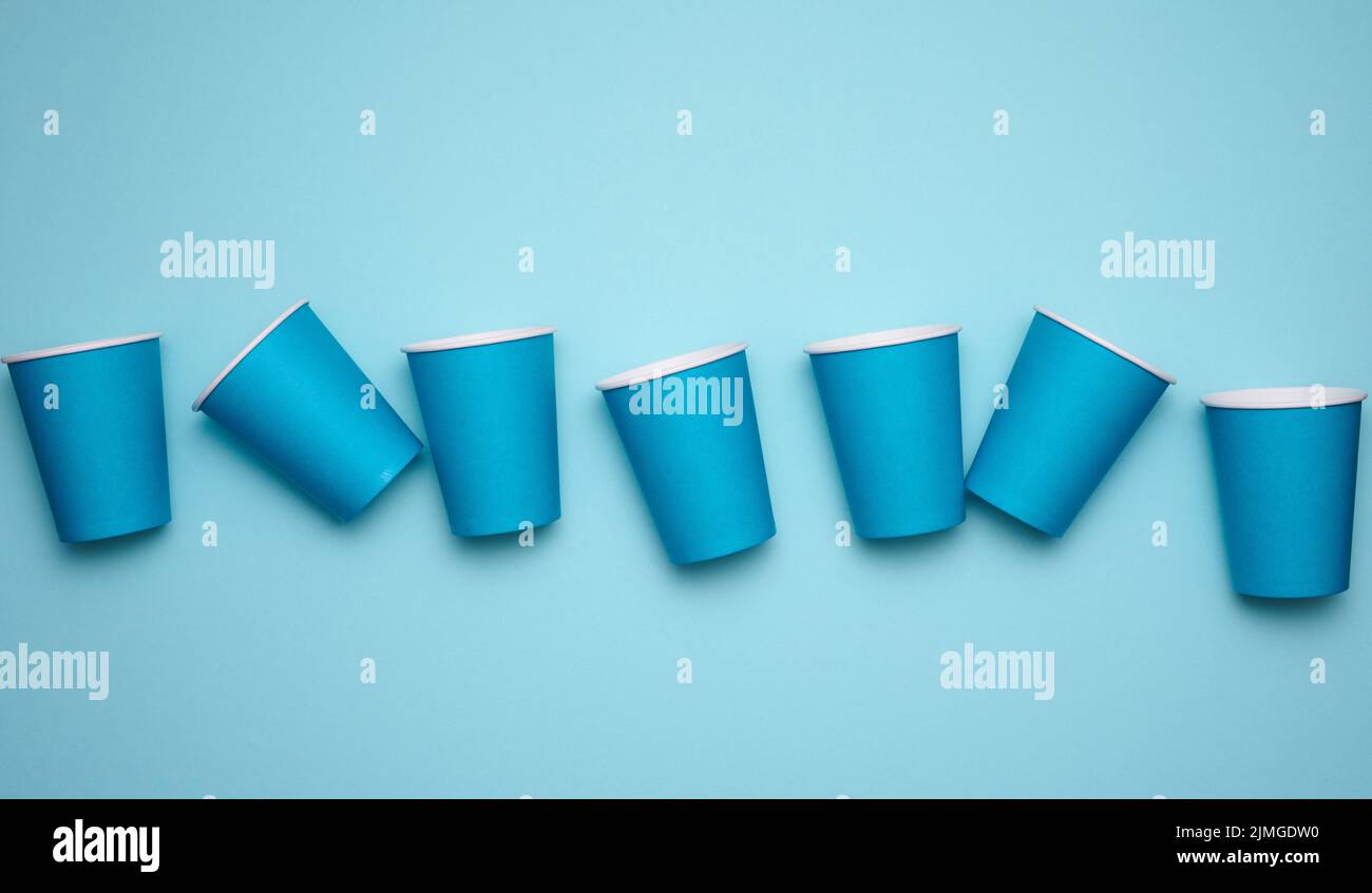 Pila di bicchieri di carta blu su sfondo blu. Concetto di rifiuto plastica, zero sprechi, vista dall'alto Foto Stock