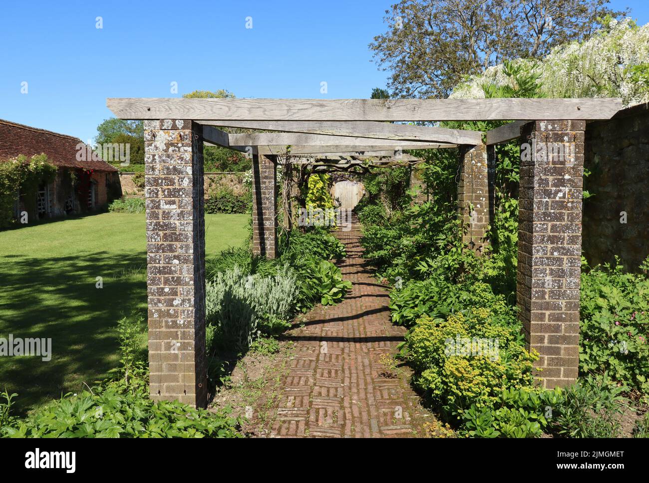 Un pergolato in legno nel terreno di una vecchia casa di campagna inglese Foto Stock