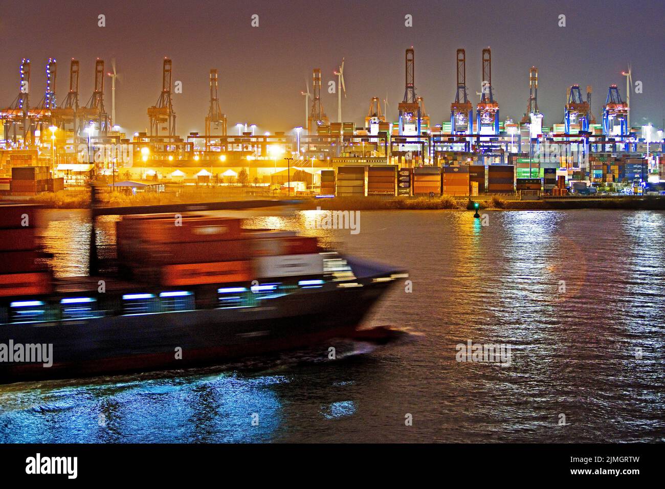 Nave portacontainer di fronte alle gru di carico presso il terminal dei container Burchardkai di notte, Amburgo Foto Stock