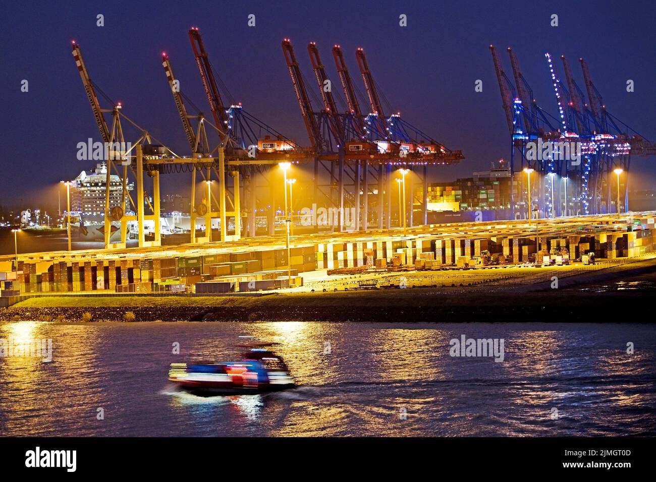 Caricare gru presso il terminal container di Tollerort la sera, porto di Amburgo, Germania Foto Stock