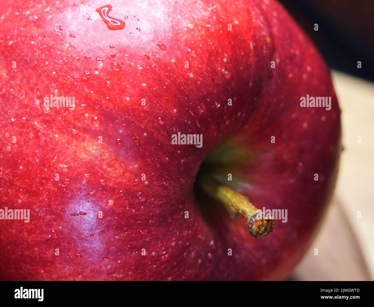 Grande mela rossa matura, macro shot. Gocce d'acqua su una buccia di mela. Un bel frutto. Foto Stock