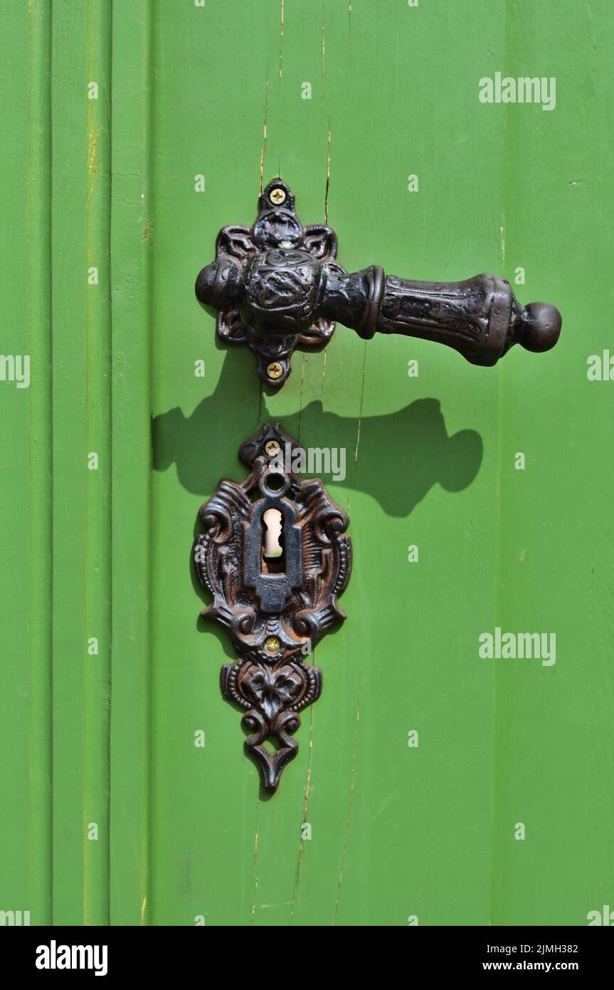 Vecchia maniglia porta su porta verde in Tata, Ungheria, verticale Foto Stock