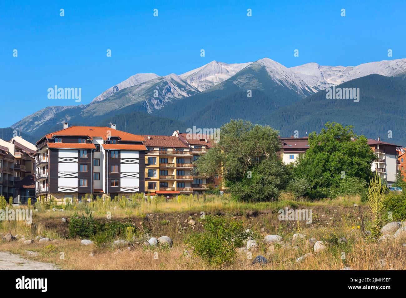 Case in legno chalet e panorama estivo montagne nella stazione sciistica bulgara Bansko, Bulgaria Foto Stock