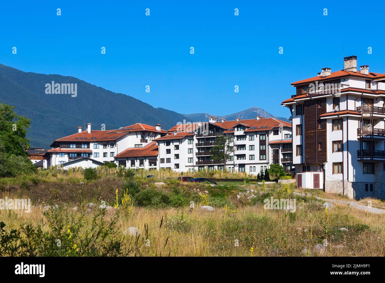 Case in legno chalet e panorama estivo montagne nella stazione sciistica bulgara Bansko, Bulgaria Foto Stock