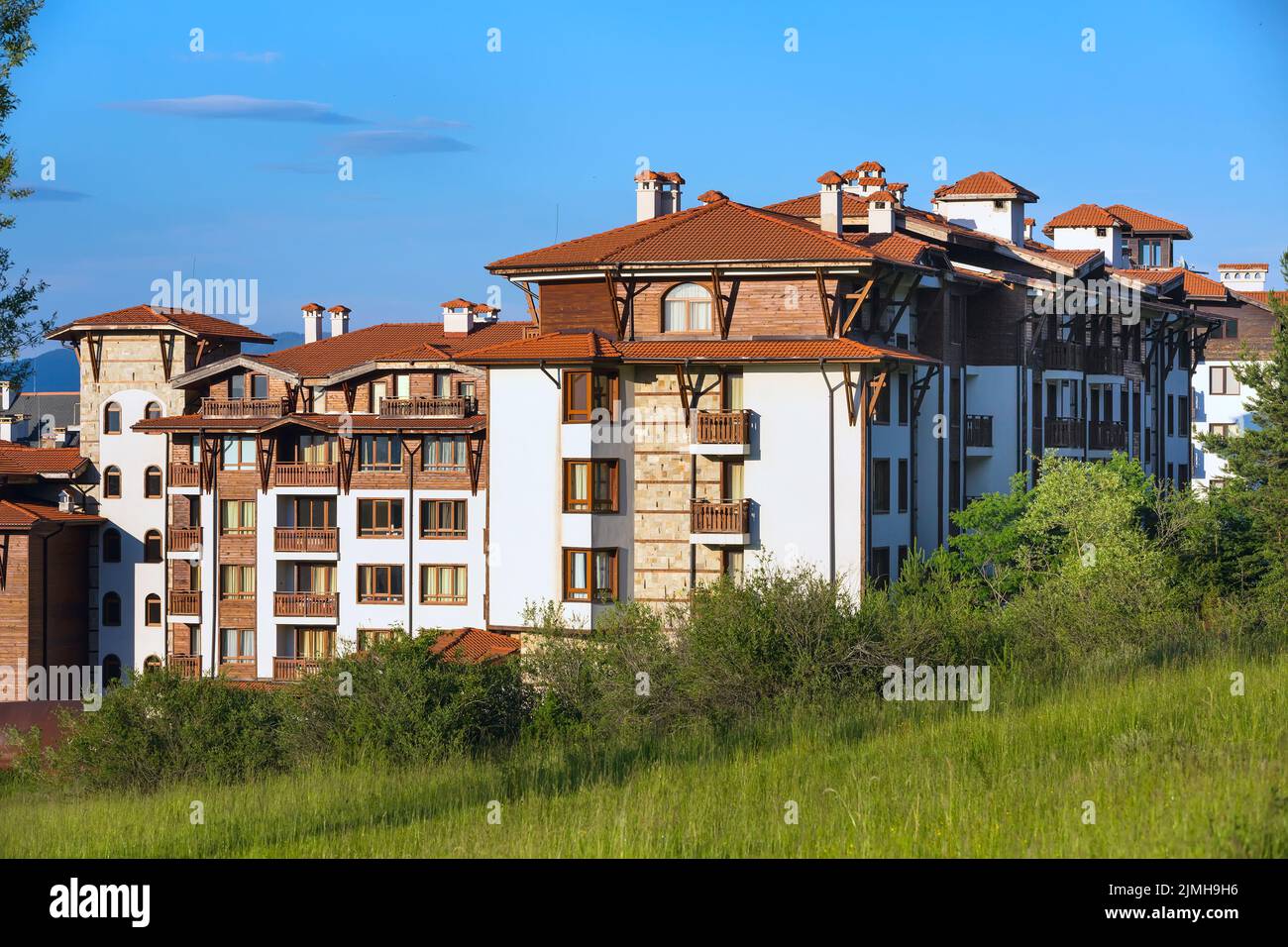 Case in legno chalet e panorama estivo montagne nella stazione sciistica bulgara Bansko, Bulgaria Foto Stock