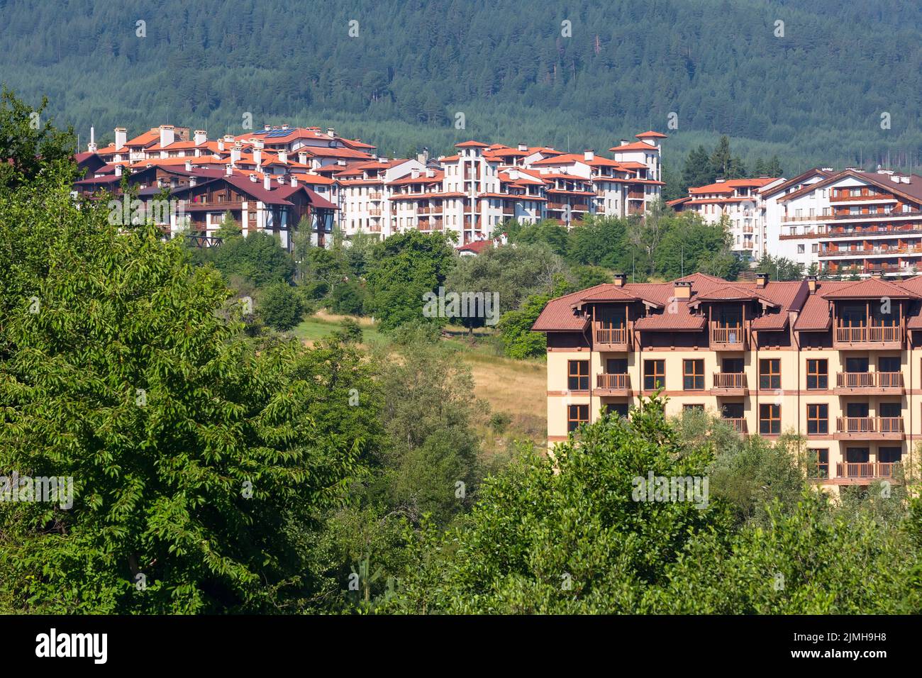 Case in legno chalet e panorama estivo montagne nella stazione sciistica bulgara Bansko, Bulgaria Foto Stock