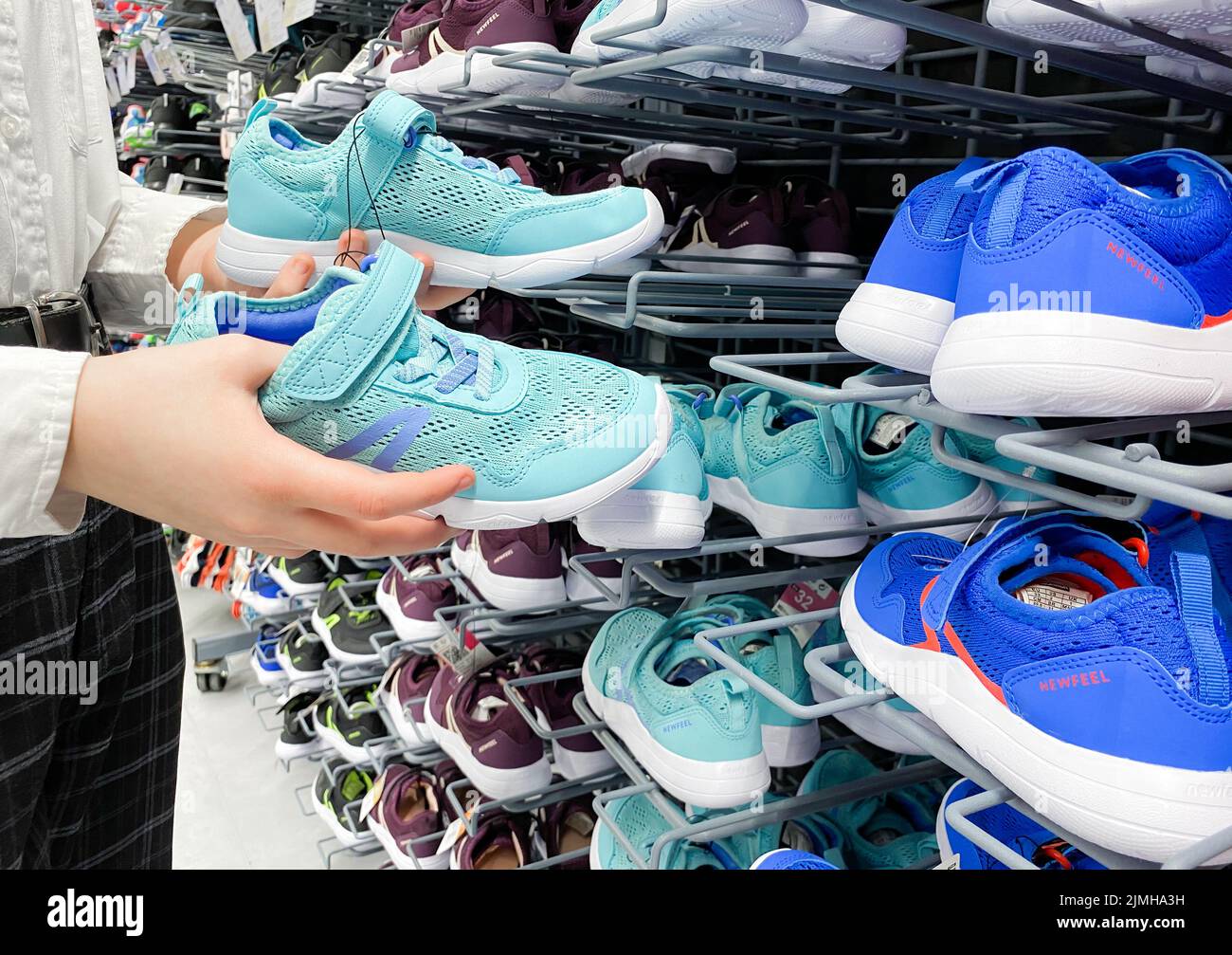 Mosca, Russia, marzo 2022: Qualcuno sceglie sneakers blu per bambini o donne nel negozio di articoli sportivi Decathlon. Foto Stock