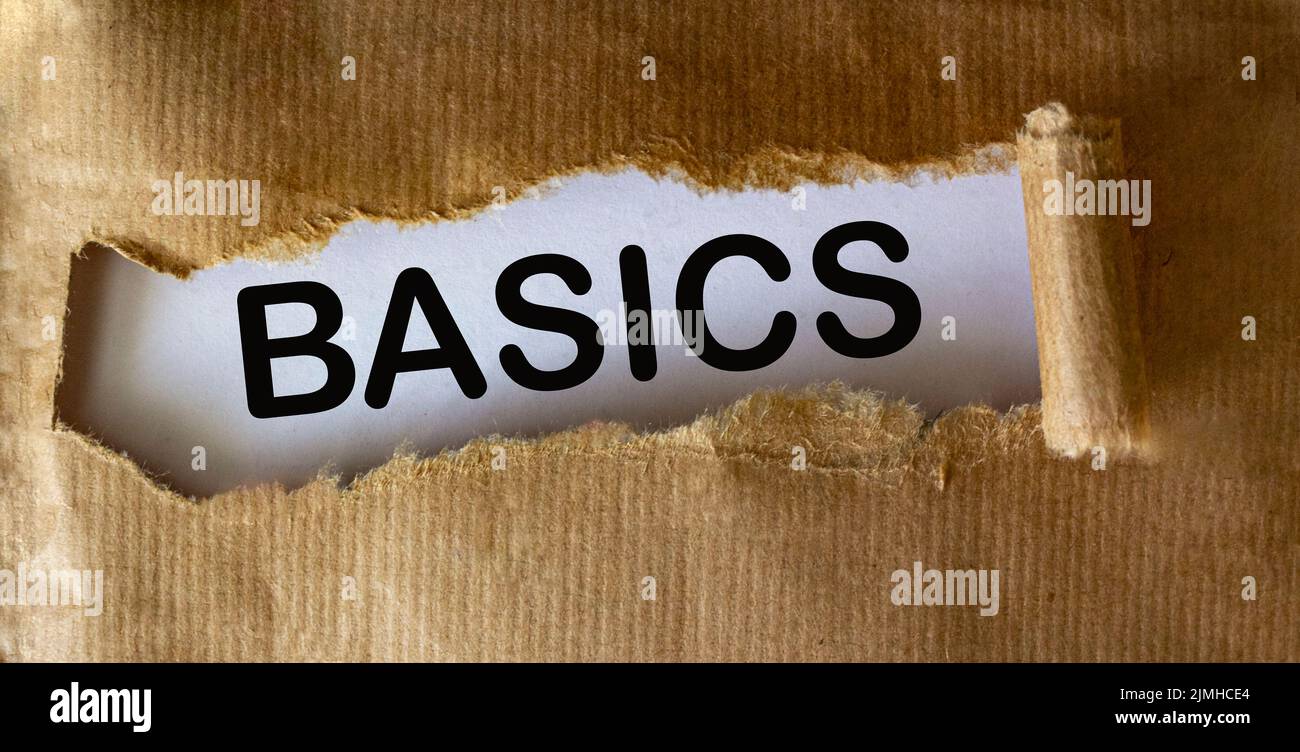 Parola DI BASE su sfondo bianco vista attraverso carta bruno strappata Foto Stock