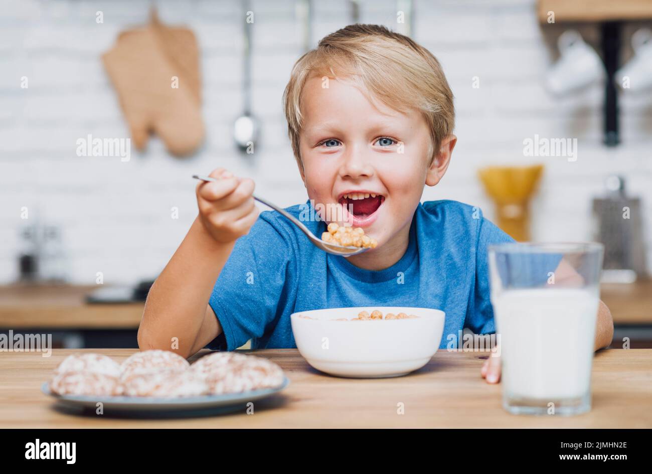 Il bambino sorridente mangia cereali Foto Stock