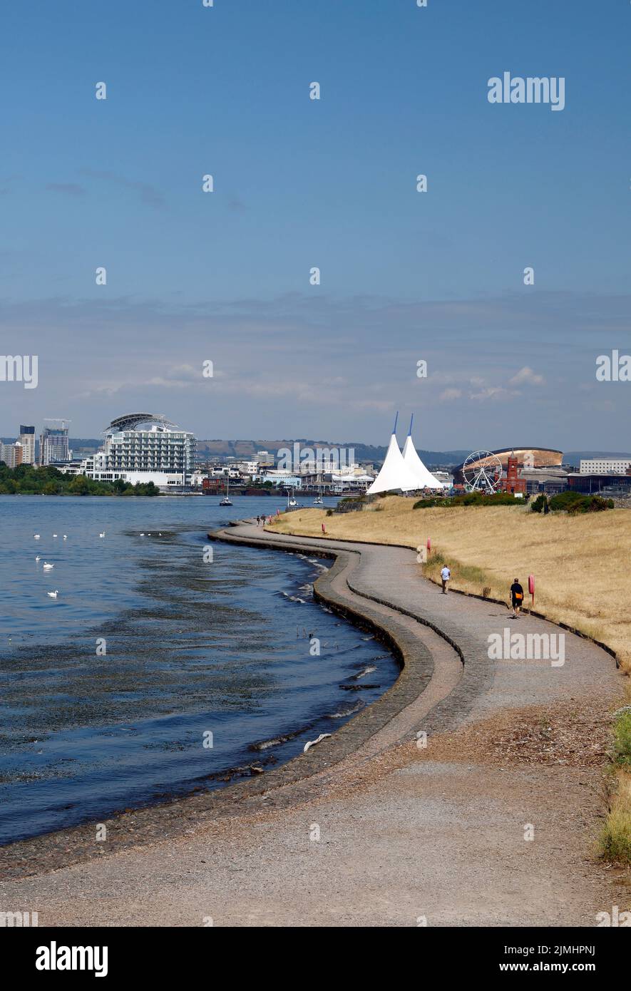 Camminatori godendo percorso tortuoso lungo la baia di Cardiff Barrage .Agosto 2022. Estate Foto Stock