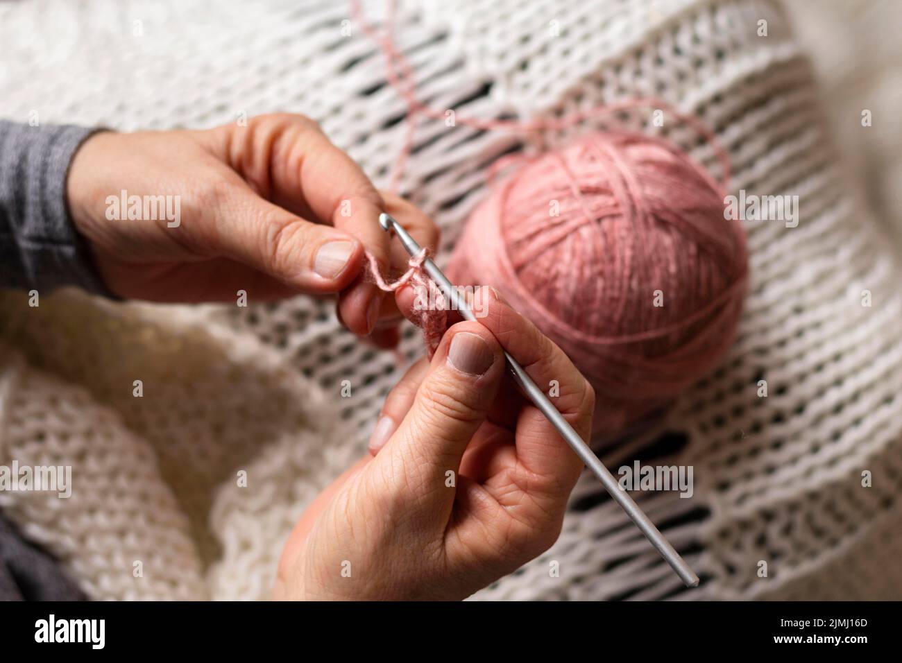 Persona in alta vista che si unisce con filo rosa Foto Stock