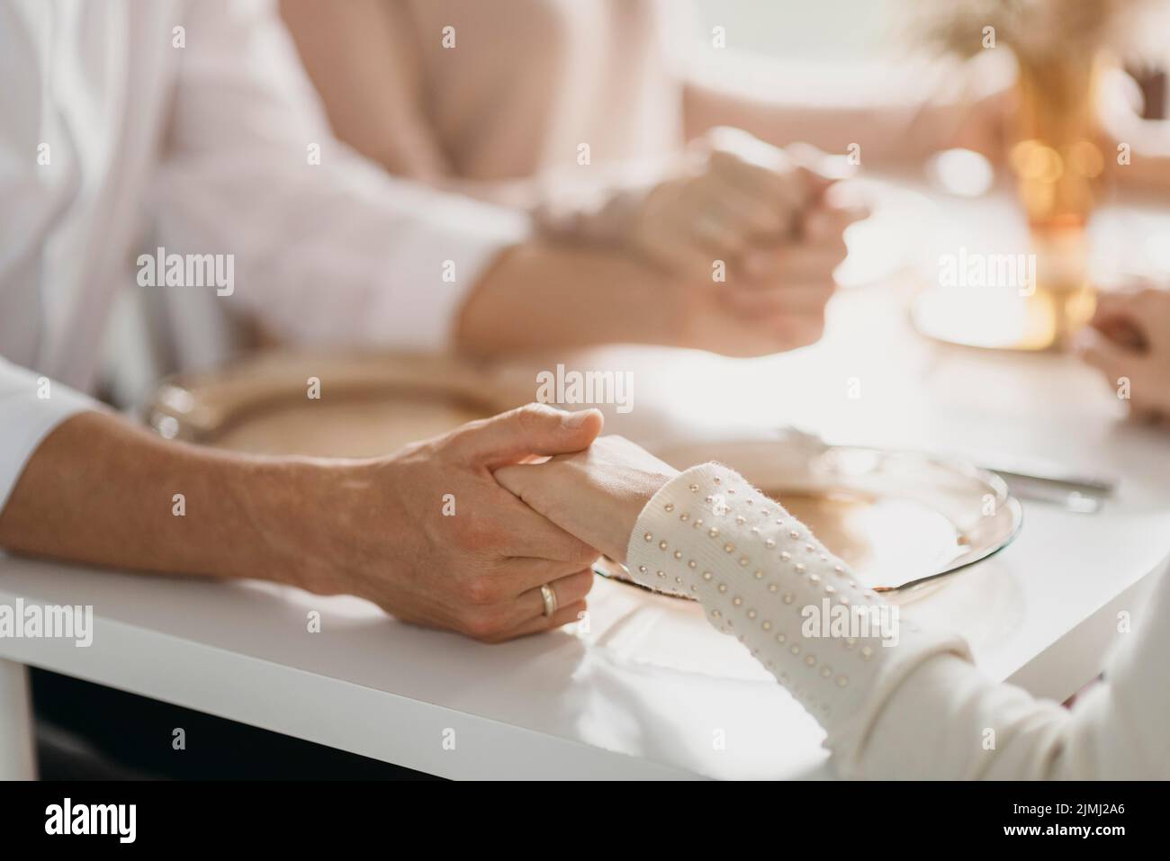 Bella famiglia che prega prima di mangiare da vicino Foto Stock