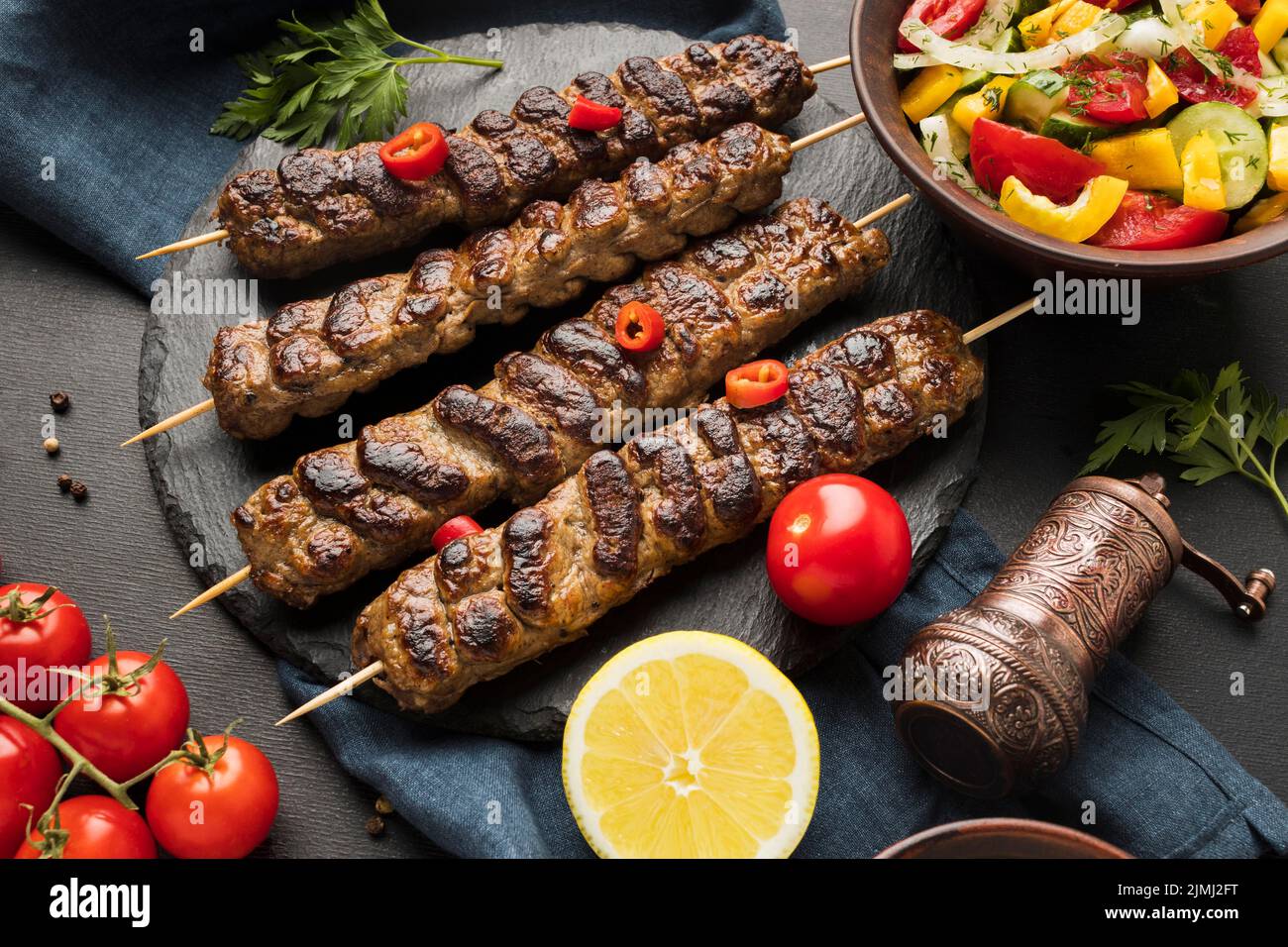 Angolo alto gustoso kebab ardesia con altri pomodori piatto Foto Stock