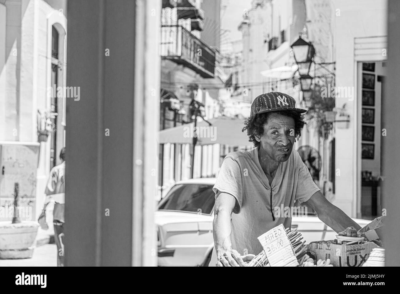Un uomo cubano alla fine degli anni Venti che vende frutta e verdura dal suo carrello. Fotografato attraverso la finestra di un ristorante. L'Avana, Cuba. Foto Stock