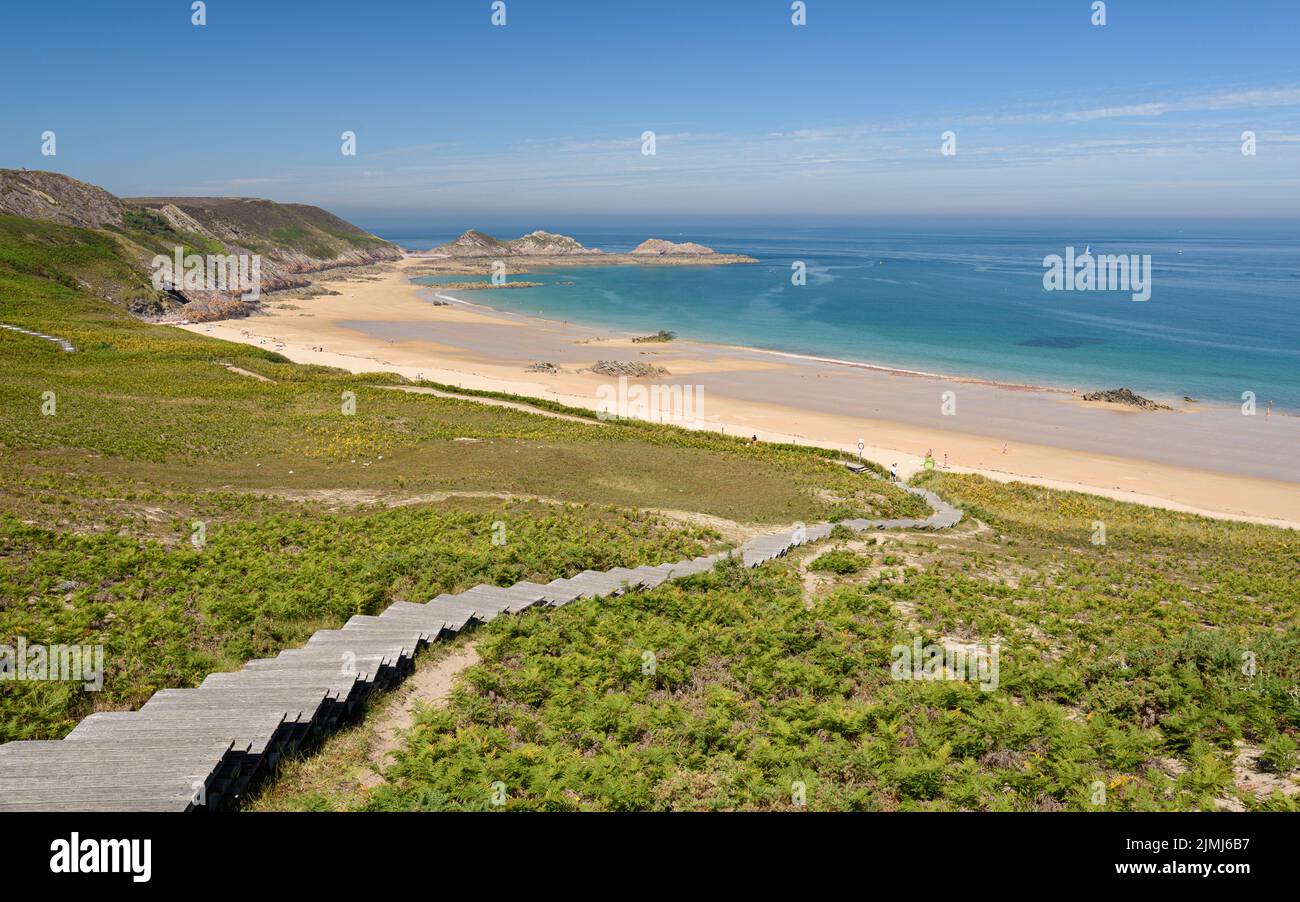 Splendido paesaggio dalla cima di una lunga scalinata naturale in legno che conduce alla spiaggia di Lourtuais vicino a capo Erquy, Bretagna, Francia. Foto Stock