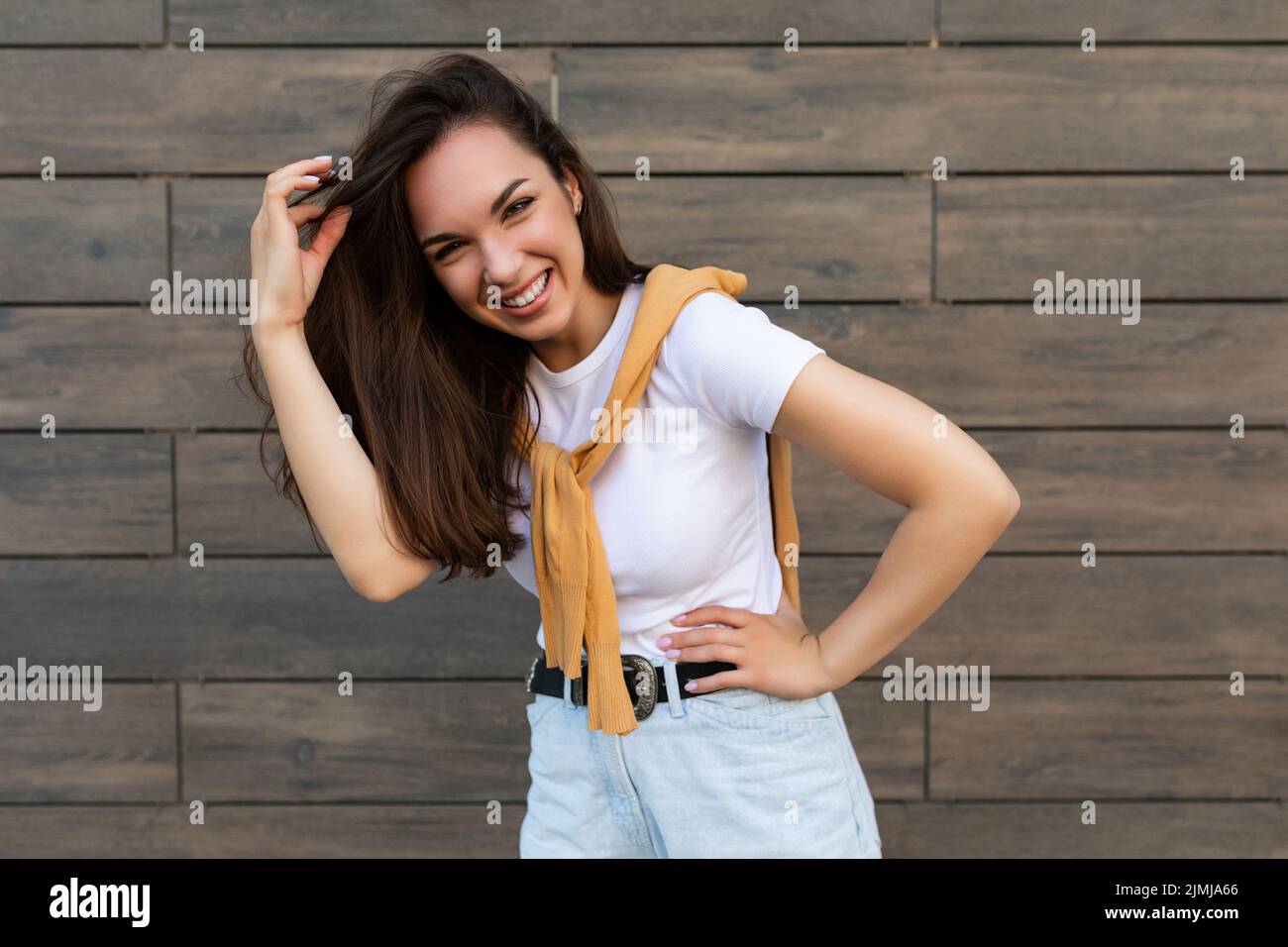 Foto di bella bella bella sorridente felice positivo affascinante giovane bruna giovane donna che indossa abiti alla moda: Bianco t Foto Stock