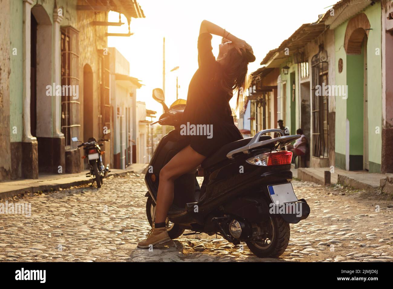 Donna viaggiatore che guida scooter per le strade della città vecchia Foto Stock