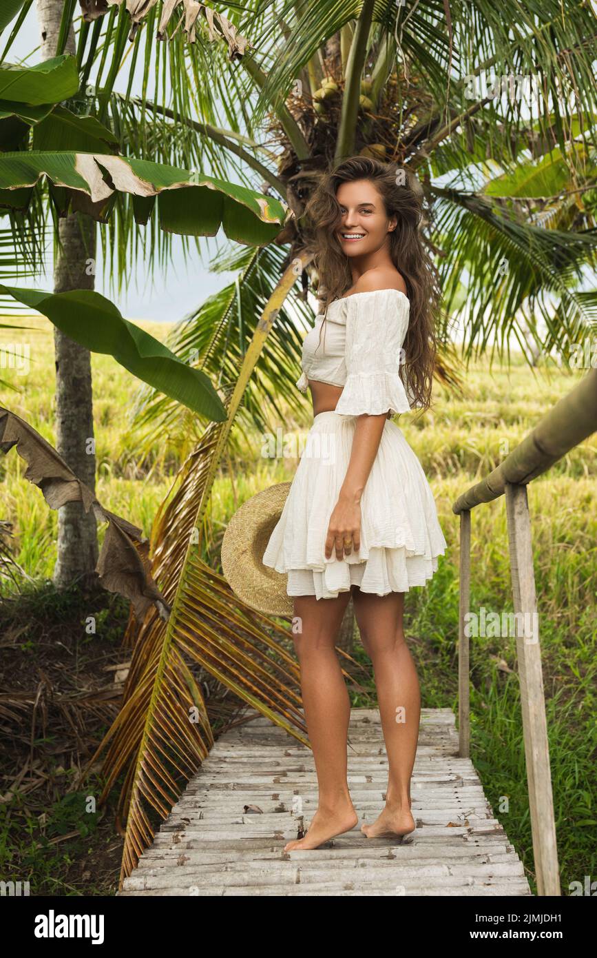 Donna che cammina vicino al vecchio ponte di legno in campagna Foto Stock