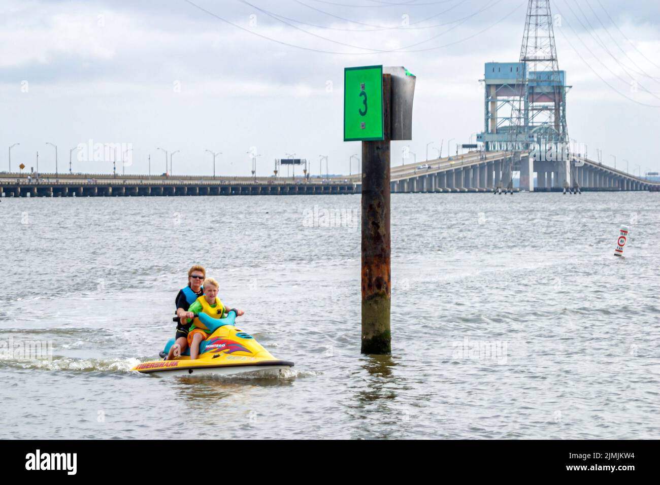 Virginia Newport News vicino a James River Bridge, pesca tempo libero bacino d'acqua molo uomo donna coppia equitazione in funzione jet ski wave runner marker, visitatori Foto Stock