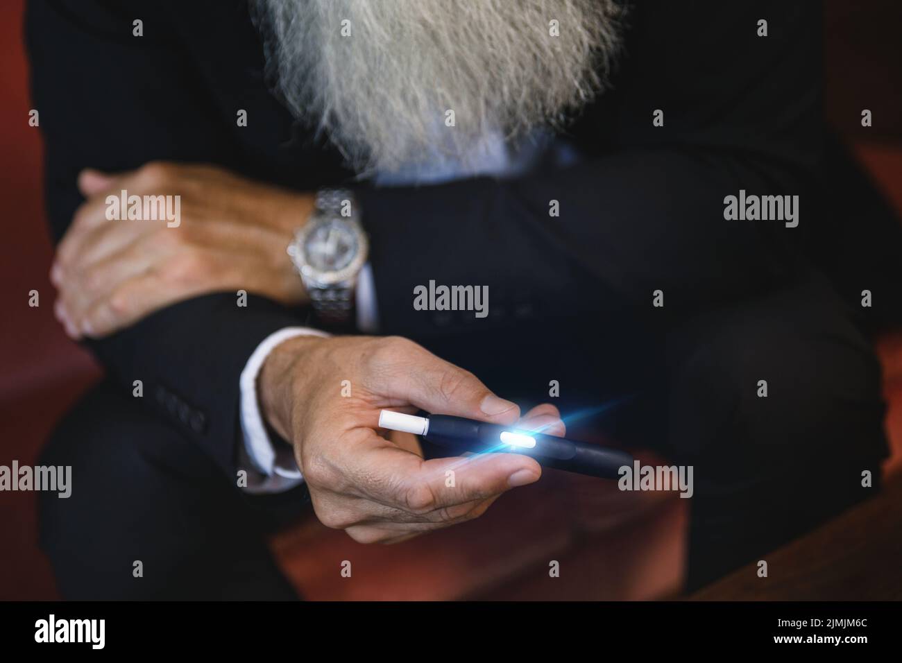 Uomo con un sistema di riscaldamento del tabacco nelle sue mani Foto Stock