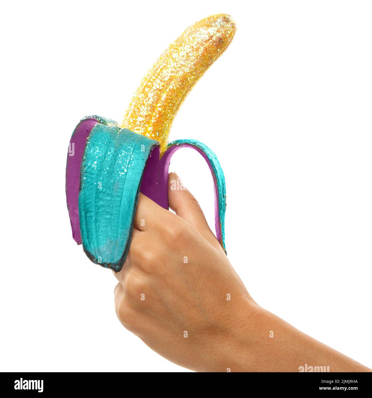 Le mani femminili e la banana ricoperte con un coloratissimo luccichy Foto Stock