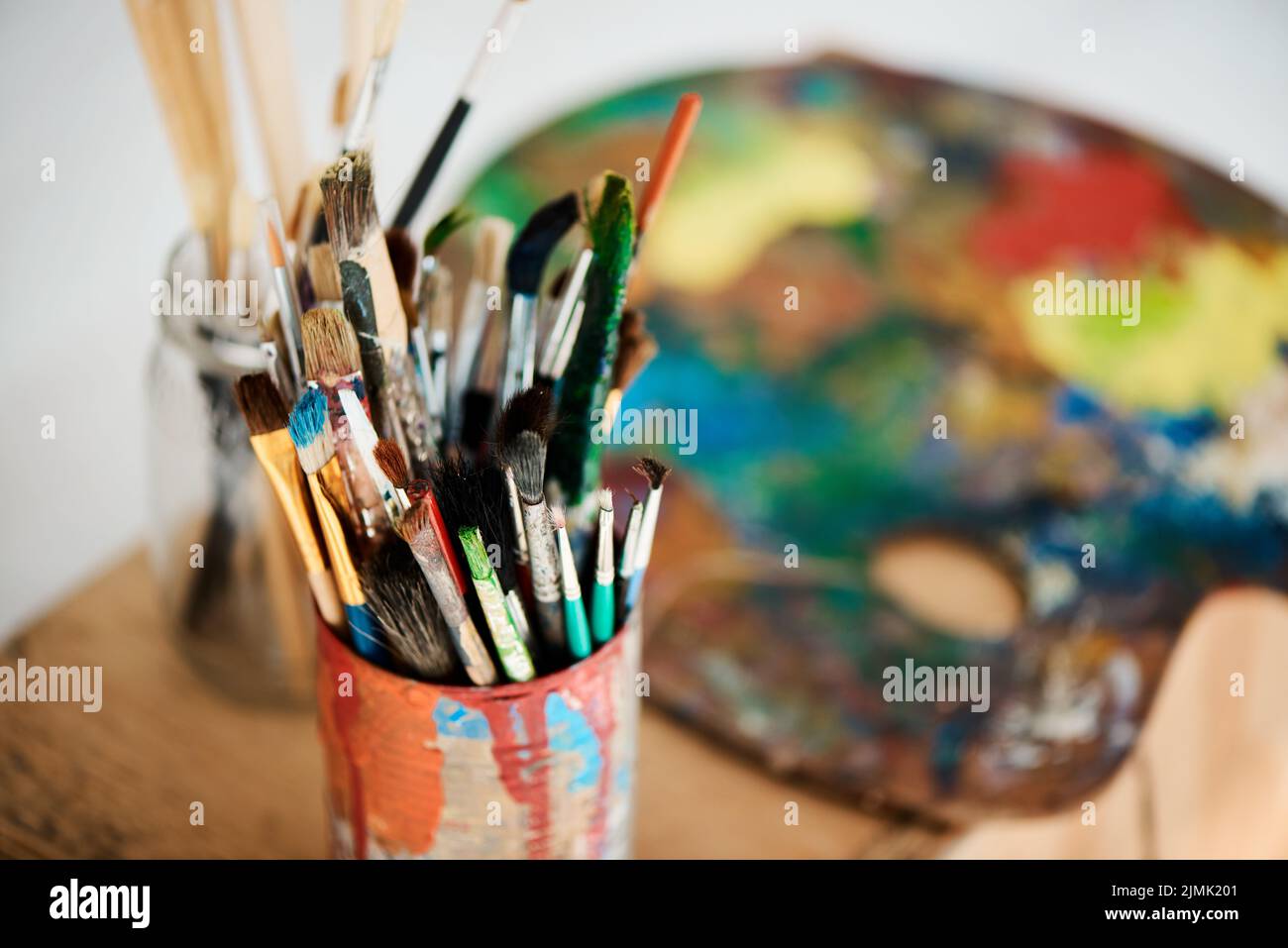 È il momento di essere creativi. Una scatola piena di pennelli in uno studio d'arte vuoto dopo una lezione di pittura. Foto Stock