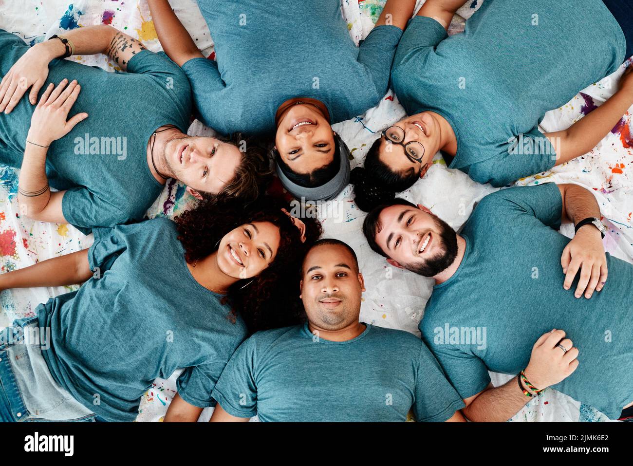 Fare una pausa. Ritratto ad angolo alto di un gruppo diversificato di amici sdraiati in un cerchio durante una classe d'arte. Foto Stock