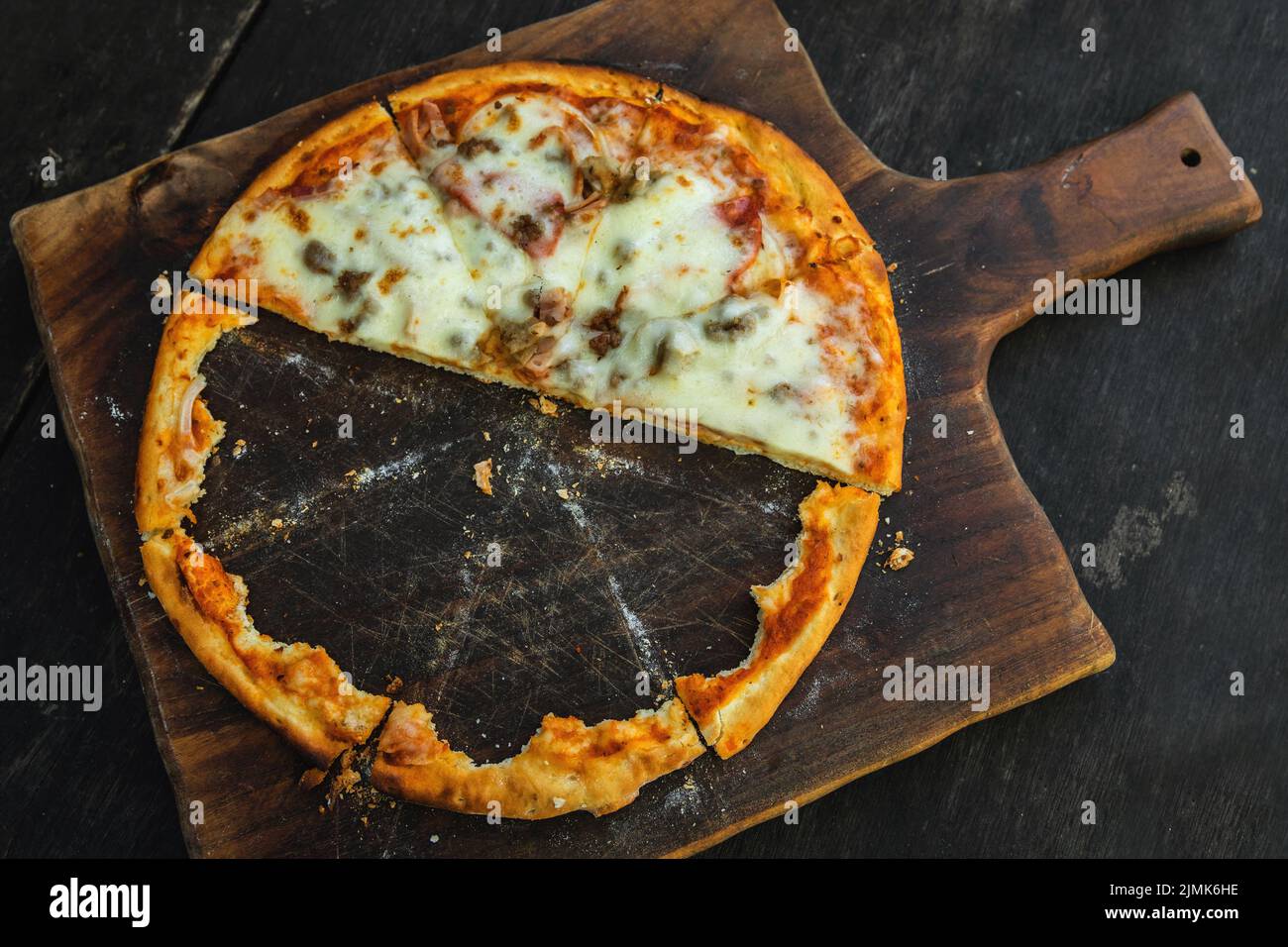 Deliziosa pizza al forno con crosta croccante su tavola di legno Foto Stock