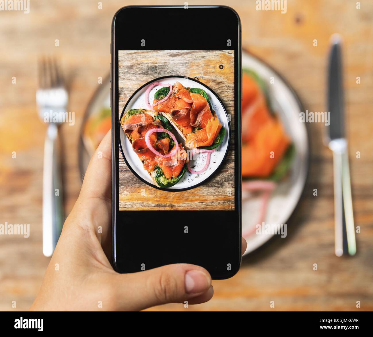 Immagine sullo schermo dello smartphone di deliziosi toast con salmone affumicato Foto Stock