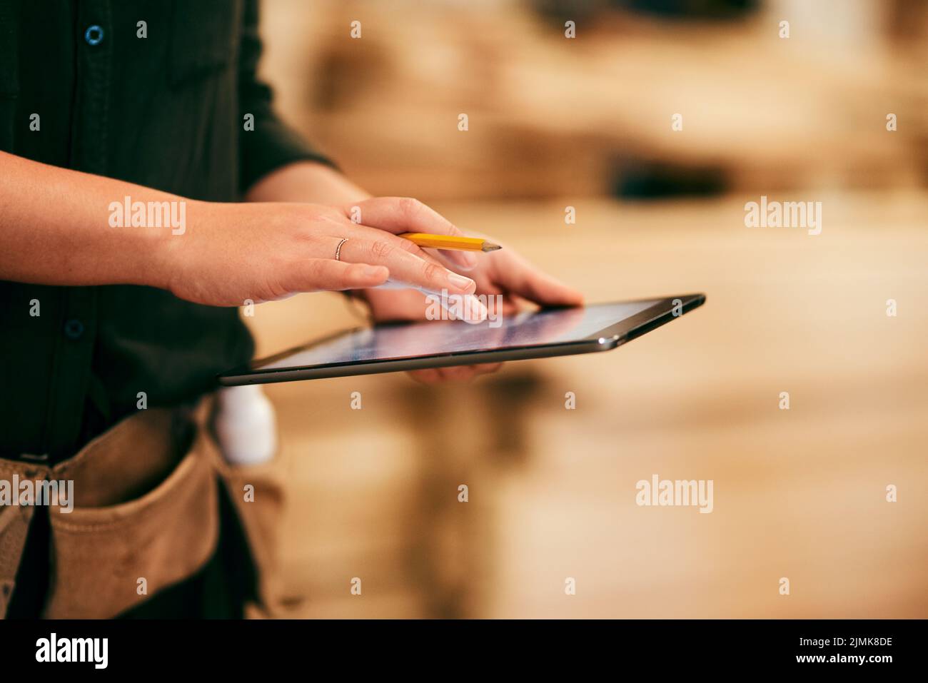 Progettare mobili non è mai stato così facile: Un carpentiere irriconoscibile che utilizza un tablet digitale nella sua officina. Foto Stock