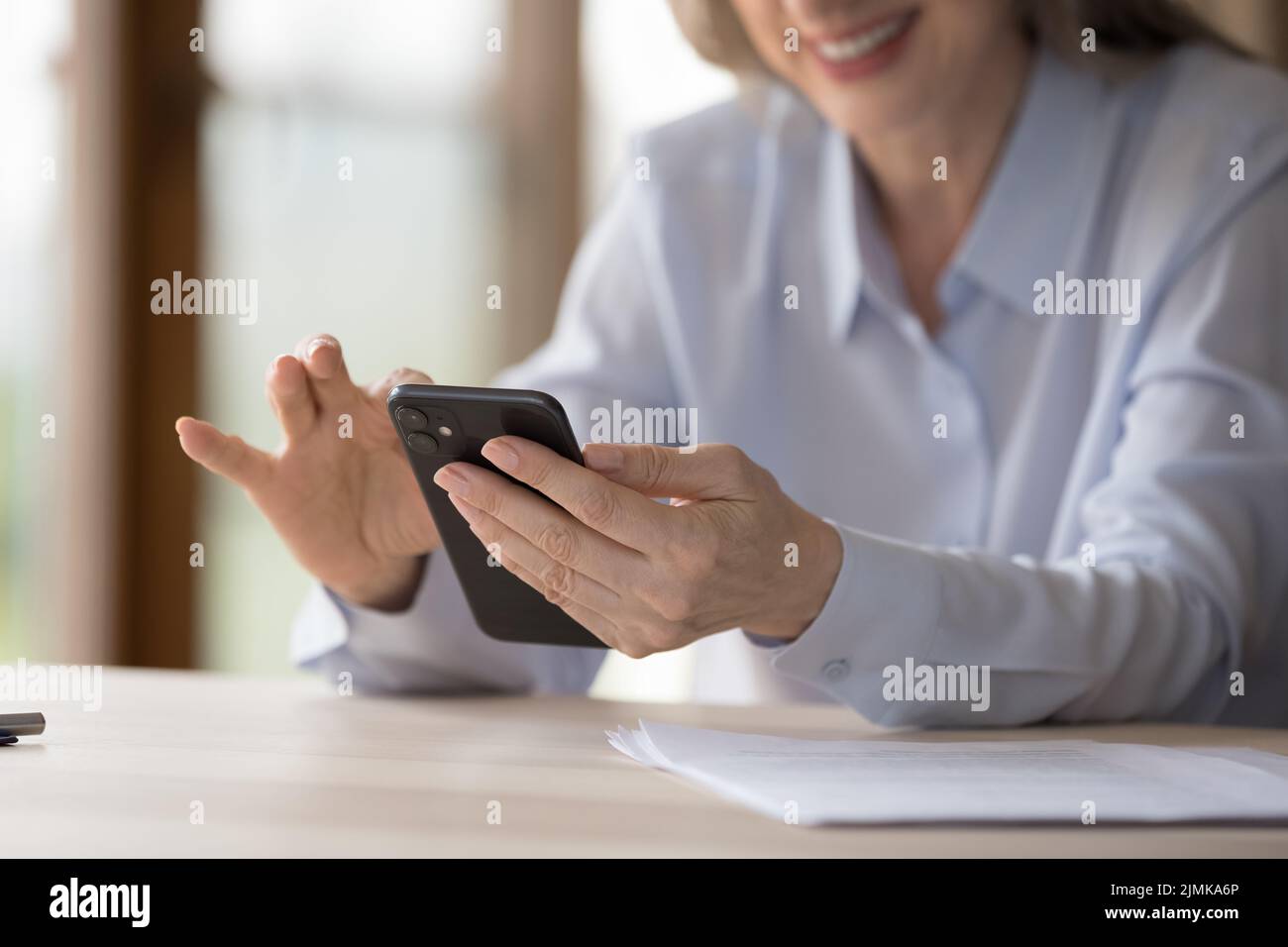 Mani di felice anziano cellulare utente donna che tiene il cellulare Foto Stock