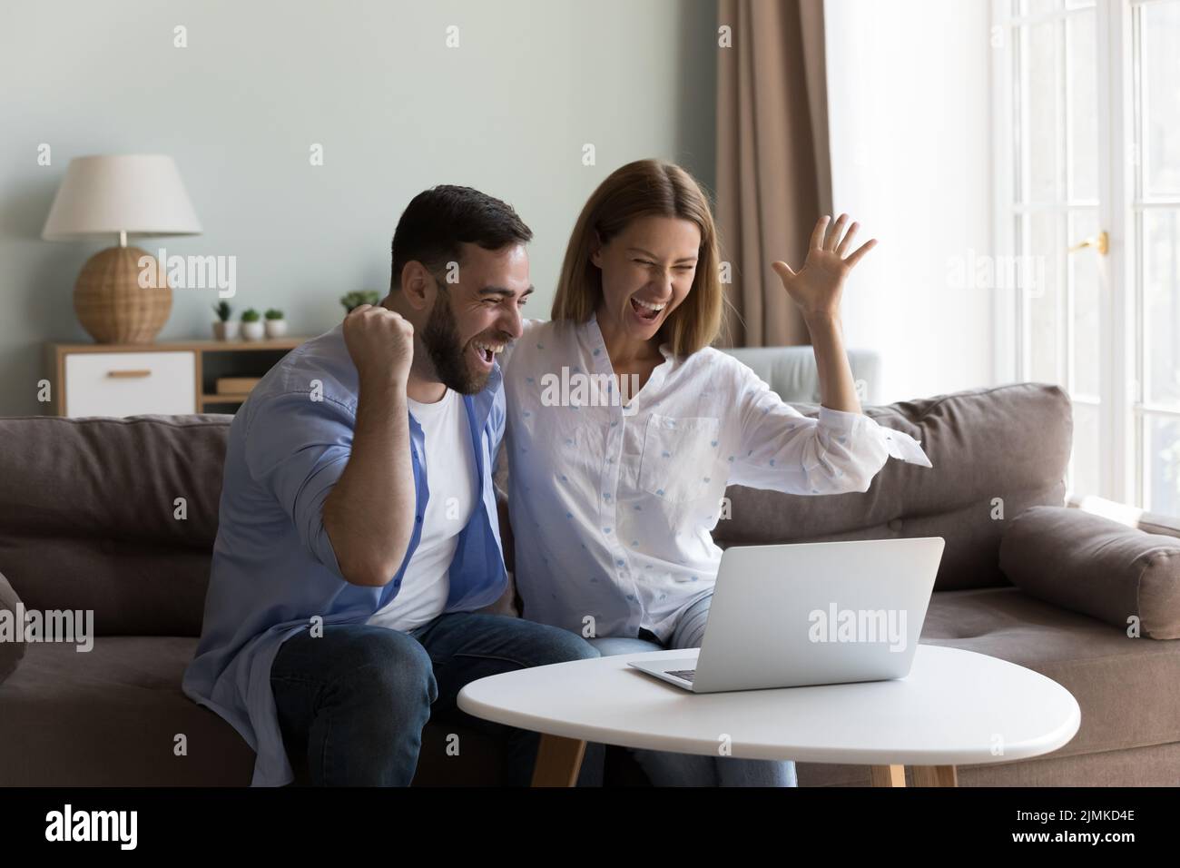 Giovane coppia si sente molto felice ottenere grandi notizie online Foto Stock