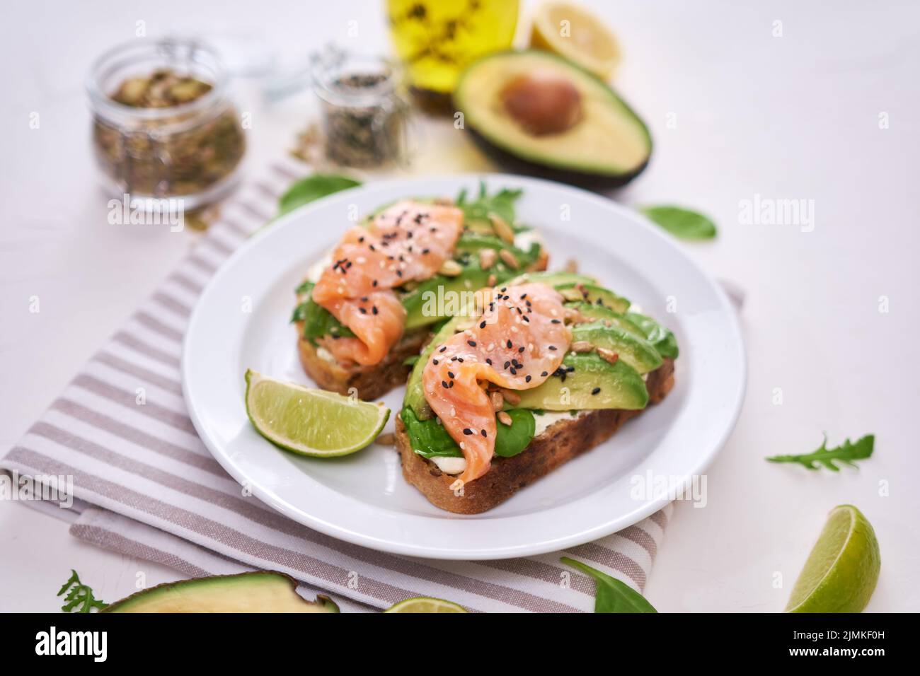 Avocado appena fatto, salmone e formaggio cremoso toast su un piatto di ceramica bianca Foto Stock