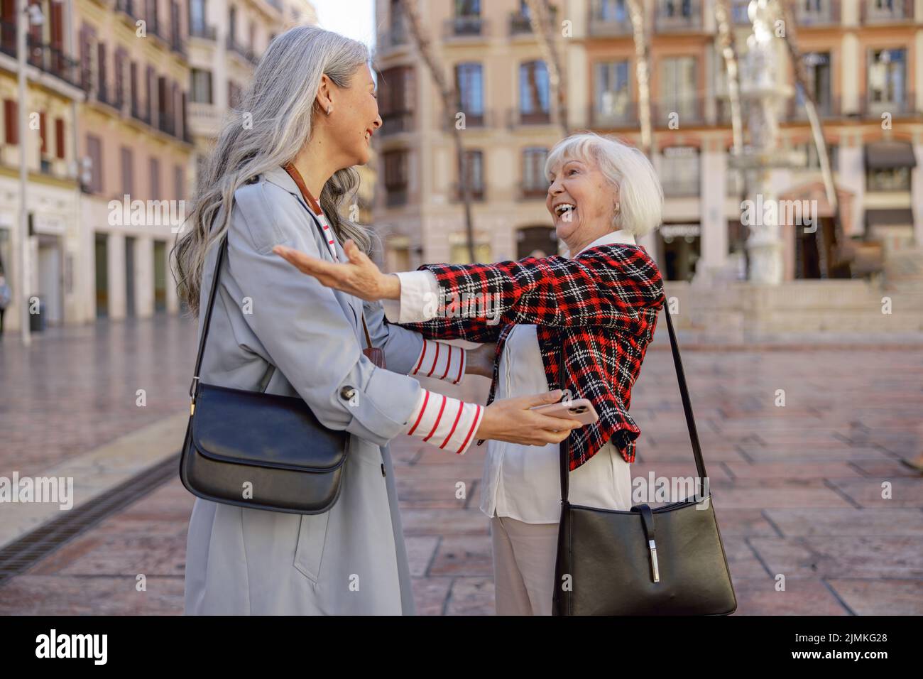 Le Signore urbane gioiscono di un incontro inaspettato in città Foto Stock