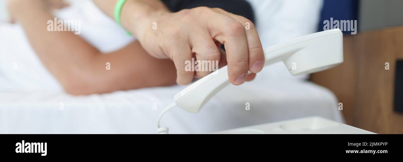 Un uomo mette giù il telefono mentre sdraiato nel letto Foto Stock